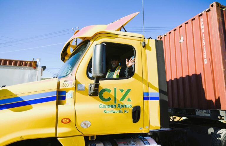A driver in a truck waving.